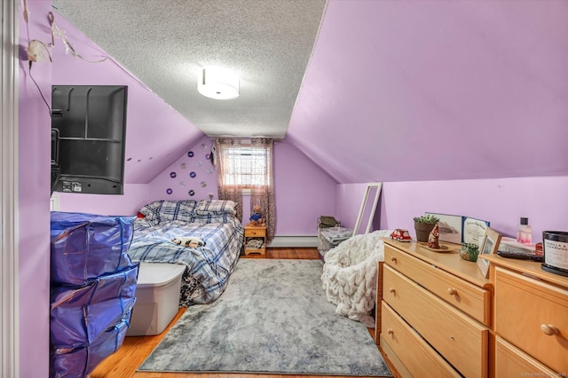 70 Birchwood Dr, Middletown, CT 06457 - bedroom featuring a baseboard heating unit, light wood-style flooring, a textured ceiling, and lofted ceiling