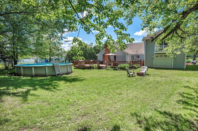 70 Birchwood Dr, Middletown, CT 06457 - view of grassy yard featuring a garage, a wooden deck, and an outdoor pool