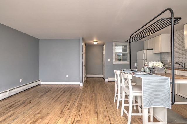 190 Wooster St Unit 27, New Haven, CT 06511 - dining area featuring light wood-style floors, a baseboard radiator, baseboard heating, and baseboards