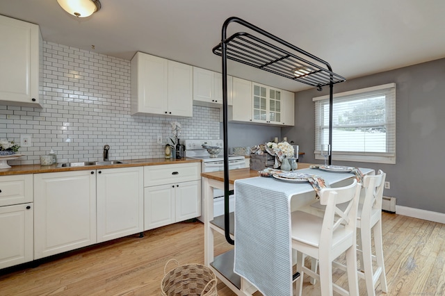 190 Wooster St Unit 27, New Haven, CT 06511 - kitchen with butcher block countertops, backsplash, light wood-style floors, baseboard heating, and white cabinets