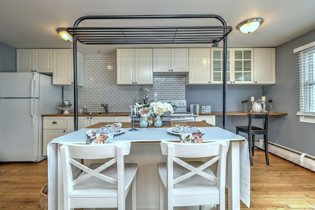 190 Wooster St Unit 27, New Haven, CT 06511 - kitchen with freestanding refrigerator, decorative backsplash, white cabinets, light wood-style flooring, and wooden counters