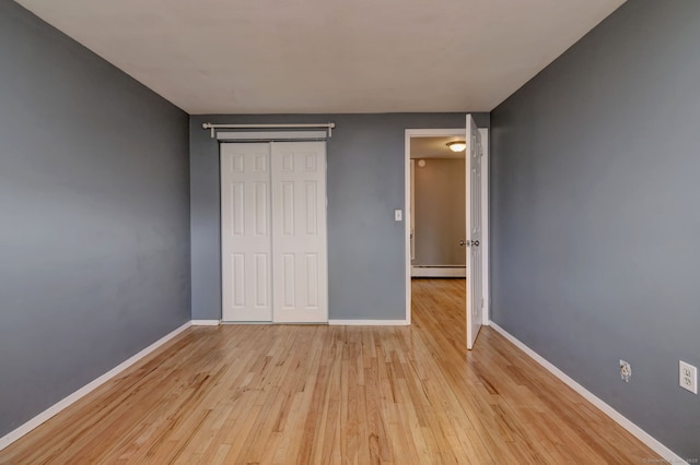 190 Wooster St Unit 27, New Haven, CT 06511 - unfurnished bedroom featuring baseboard heating, light wood-style flooring, baseboards, and a closet