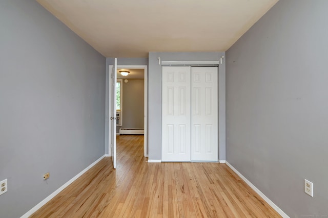 190 Wooster St Unit 27, New Haven, CT 06511 - unfurnished bedroom featuring baseboard heating, light wood finished floors, a closet, and baseboards