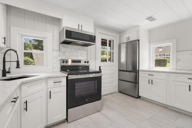 30 Buena Vista St, Farmington, CT 06085 - kitchen with stainless steel appliances, a sink, backsplash, white cabinets, and light stone counters