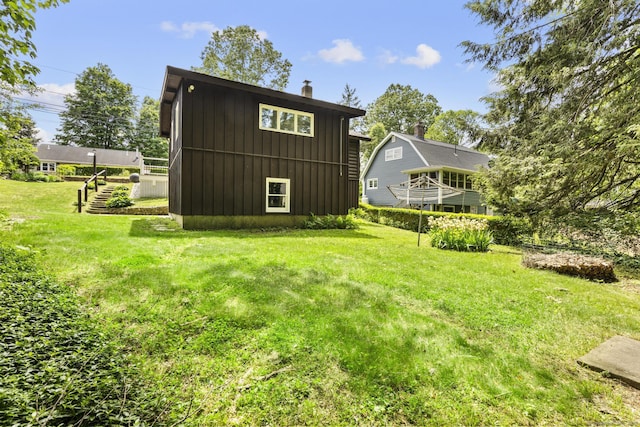 30 Buena Vista St, Farmington, CT 06085 - rear view of house with board and batten siding, a chimney, and a lawn