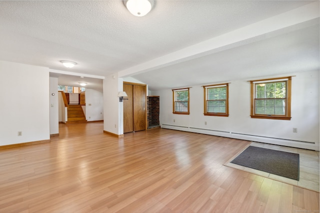 49 Longwood Dr, East Haddam, CT 06415 - unfurnished room featuring stairway, a baseboard heating unit, light wood finished floors, a textured ceiling, and vaulted ceiling