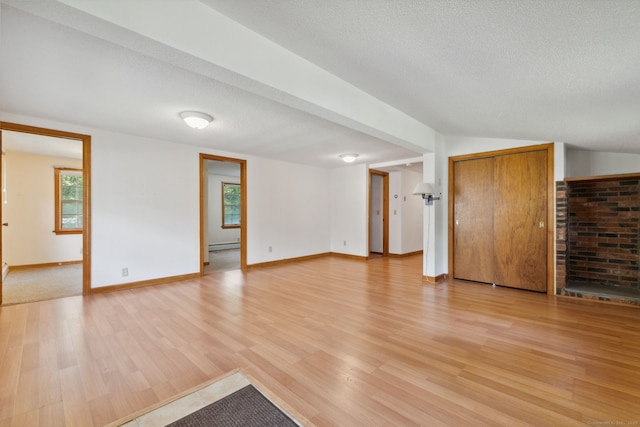 49 Longwood Dr, East Haddam, CT 06415 - unfurnished living room with light wood-style flooring, a baseboard radiator, baseboards, and a textured ceiling