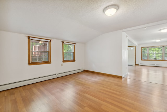 49 Longwood Dr, East Haddam, CT 06415 - spare room with a baseboard radiator, light wood-style flooring, lofted ceiling, a textured ceiling, and baseboards