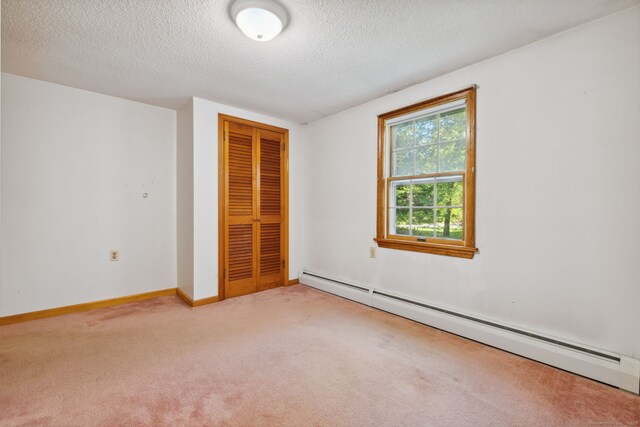 49 Longwood Dr, East Haddam, CT 06415 - unfurnished bedroom with baseboard heating, carpet, a closet, a textured ceiling, and baseboards