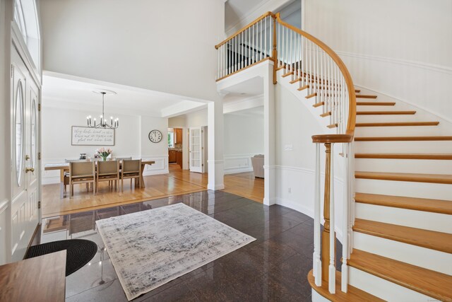 35 Bart Dr, Canton, CT 06019 - entryway featuring stairway, a high ceiling, a chandelier, a wainscoted wall, and granite tiled floors