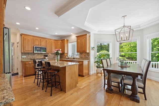 35 Bart Dr, Canton, CT 06019 - kitchen featuring stainless steel appliances, crown molding, a center island, a kitchen bar, and decorative backsplash