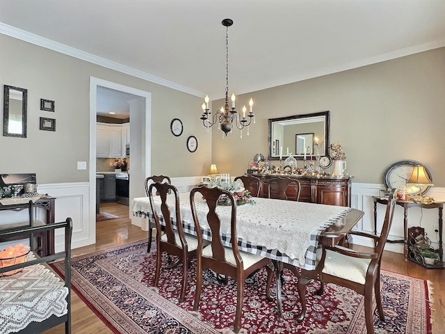 16 Trevor Ln, East Granby, CT 06026 - dining space with a chandelier, a wainscoted wall, crown molding, light wood finished floors, and a decorative wall