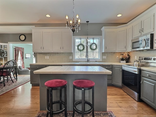 16 Trevor Ln, East Granby, CT 06026 - kitchen featuring appliances with stainless steel finishes, a sink, tile countertops, a chandelier, and gray cabinets