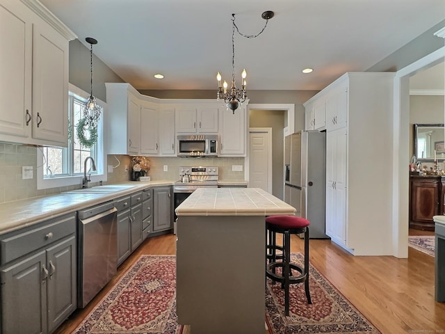 16 Trevor Ln, East Granby, CT 06026 - kitchen featuring stainless steel appliances, gray cabinets, tile countertops, a sink, and a chandelier