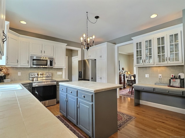 16 Trevor Ln, East Granby, CT 06026 - kitchen with appliances with stainless steel finishes, tile counters, white cabinets, a chandelier, and recessed lighting