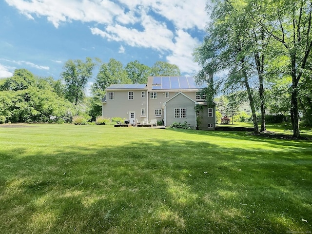 16 Trevor Ln, East Granby, CT 06026 - rear view of house with roof mounted solar panels and a lawn