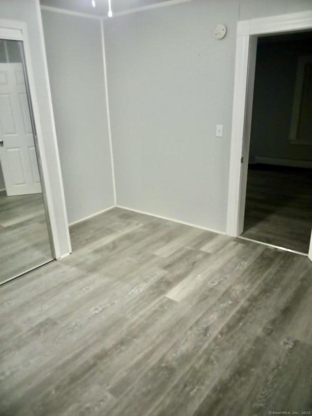 100 Roosevelt Ave, Torrington, CT 06790 - unfurnished bedroom with wood finished floors, a closet, and a baseboard radiator