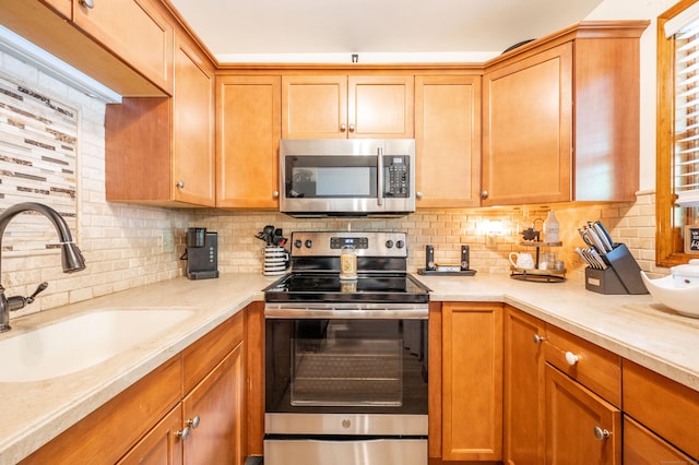 13 Hidden Knolls Cir Unit 13, Monroe, CT 06468 - kitchen featuring stainless steel appliances, a sink, decorative backsplash, and light stone counters