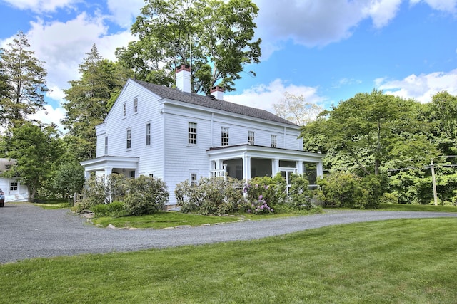 587 Carter St, New Canaan, CT 06840 - view of front of property with a chimney, a front lawn, and a sunroom