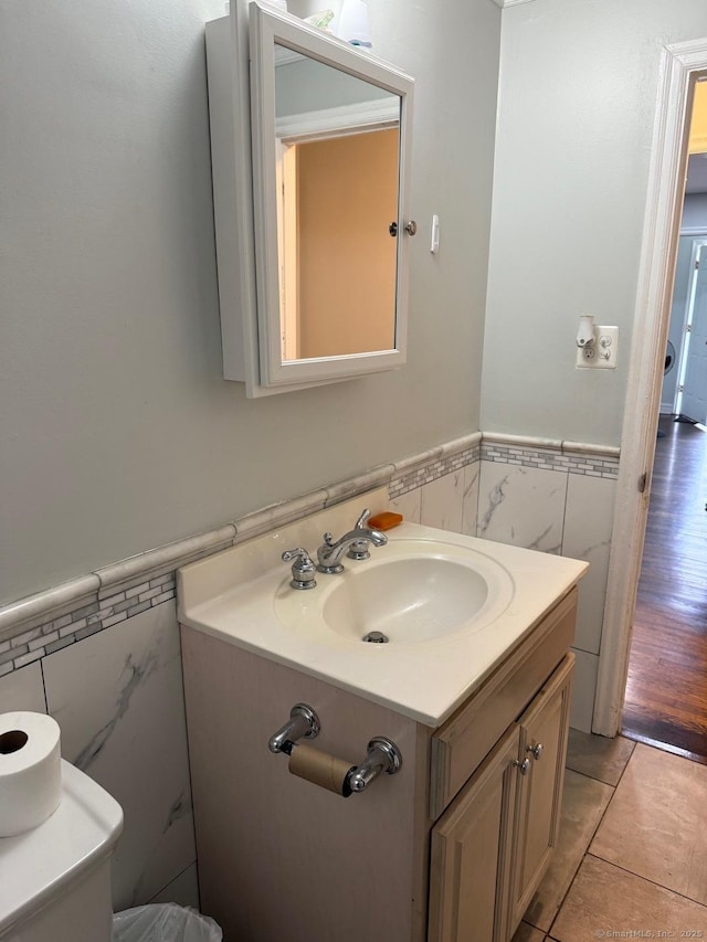 240 Beechmont Ave, Bridgeport, CT 06606 - half bathroom with tile walls, a wainscoted wall, vanity, toilet, and tile patterned floors