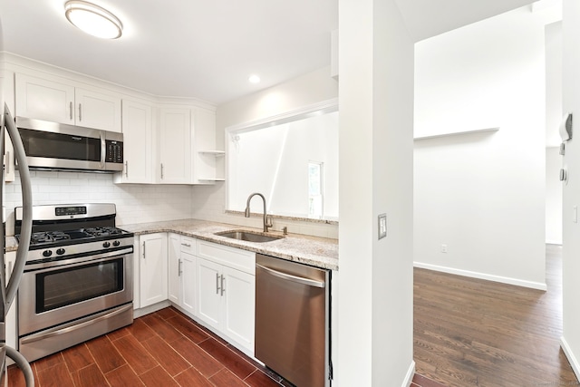 27 Pheasant Run Unit 27, Cromwell, CT 06416 - kitchen featuring stainless steel appliances, a sink, dark wood-style floors, light stone countertops, and decorative backsplash
