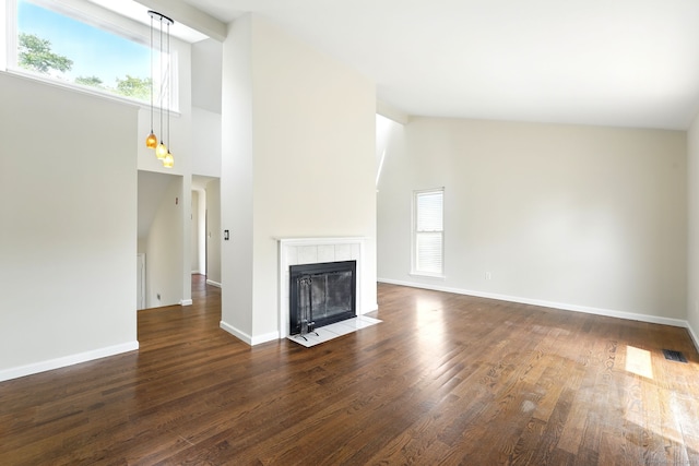 27 Pheasant Run Unit 27, Cromwell, CT 06416 - unfurnished living room with dark wood finished floors, high vaulted ceiling, baseboards, and a tile fireplace
