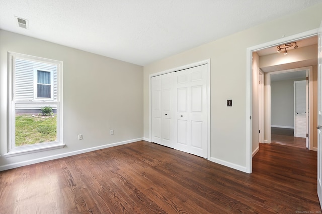 27 Pheasant Run Unit 27, Cromwell, CT 06416 - unfurnished bedroom with baseboards, dark wood-type flooring, and a closet