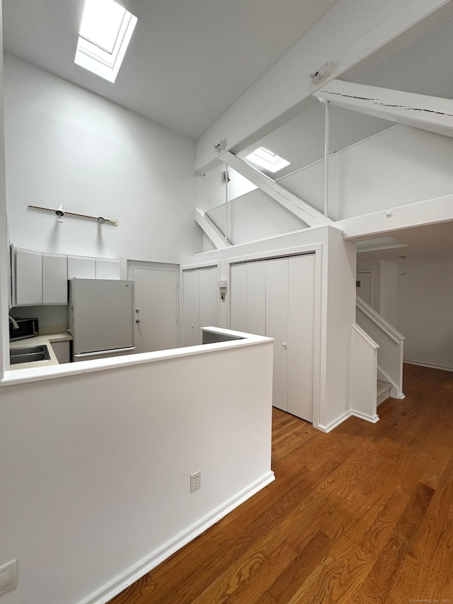 32 Pine St Unit 12Aka 15, Norwalk, CT 06854 - kitchen with freestanding refrigerator, a skylight, wood finished floors, high vaulted ceiling, and beamed ceiling