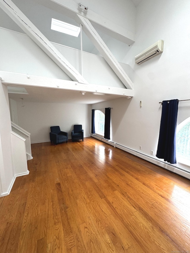 32 Pine St Unit 12Aka 15, Norwalk, CT 06854 - unfurnished living room featuring a wall mounted air conditioner, wood finished floors, beam ceiling, a skylight, and baseboards