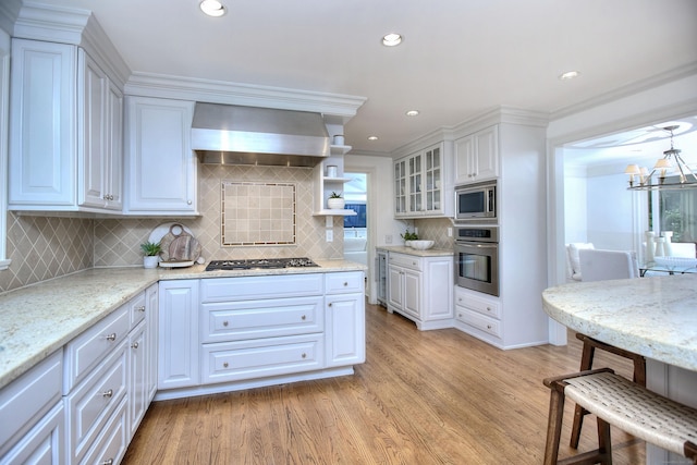 52 Woodside Ave, Westport, CT 06880 - kitchen featuring extractor fan, stainless steel appliances, light wood-style flooring, white cabinetry, and backsplash