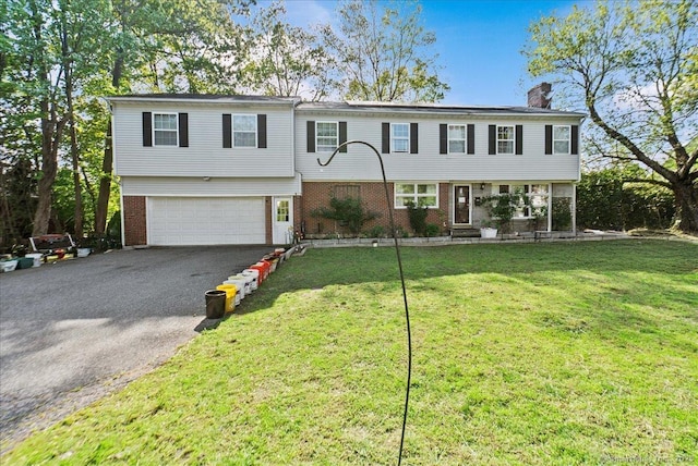 146 Whitewood Rd, Torrington, CT 06790 - view of front of home with a chimney, driveway, brick siding, an attached garage, and a front yard