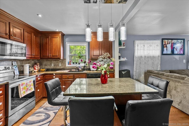146 Whitewood Rd, Torrington, CT 06790 - kitchen with appliances with stainless steel finishes, open floor plan, a breakfast bar area, and light wood-style flooring