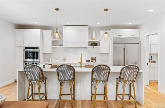 10 Singing Woods Rd, Norwalk, CT 06850 - kitchen featuring appliances with stainless steel finishes, light countertops, custom exhaust hood, an island with sink, and open shelves