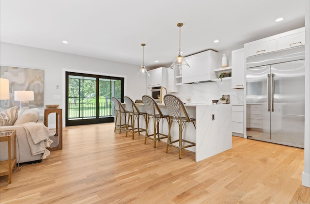 10 Singing Woods Rd, Norwalk, CT 06850 - kitchen featuring stainless steel appliances, open shelves, white cabinets, a kitchen breakfast bar, and light wood-style flooring