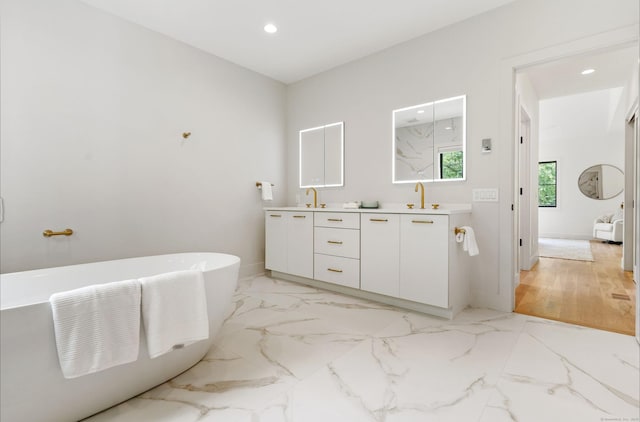10 Singing Woods Rd, Norwalk, CT 06850 - full bathroom featuring double vanity, a freestanding tub, recessed lighting, and marble finish floors