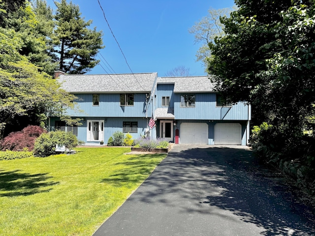 10 Laurel Trl, Durham, CT 06422 - view of front of home featuring a shingled roof, driveway, a garage, a front yard, and a chimney