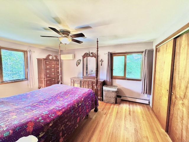 10 Laurel Trl, Durham, CT 06422 - bedroom with an AC wall unit, a baseboard heating unit, light wood-type flooring, a ceiling fan, and a closet