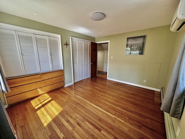 10 Laurel Trl, Durham, CT 06422 - unfurnished bedroom with a wall mounted AC, wood finished floors, baseboards, and a baseboard radiator