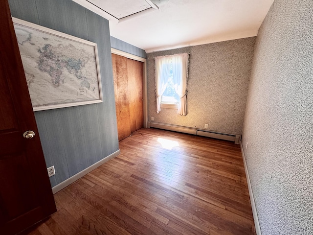 10 Laurel Trl, Durham, CT 06422 - unfurnished bedroom with a baseboard heating unit, wood finished floors, baseboards, a closet, and attic access