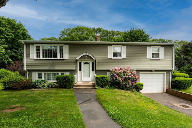 39 Ivy Dr, Southington, CT 06489 - split foyer home featuring asphalt driveway, an attached garage, a front yard, and a chimney