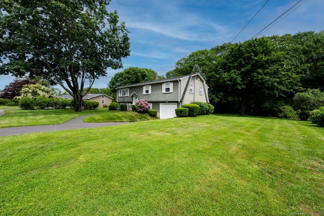 39 Ivy Dr, Southington, CT 06489 - view of front of house with a garage, asphalt driveway, a chimney, and a front yard