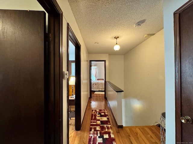 82 Louisiana Ave, Bridgeport, CT 06610 - hallway with light wood-style floors, a textured ceiling, and baseboards