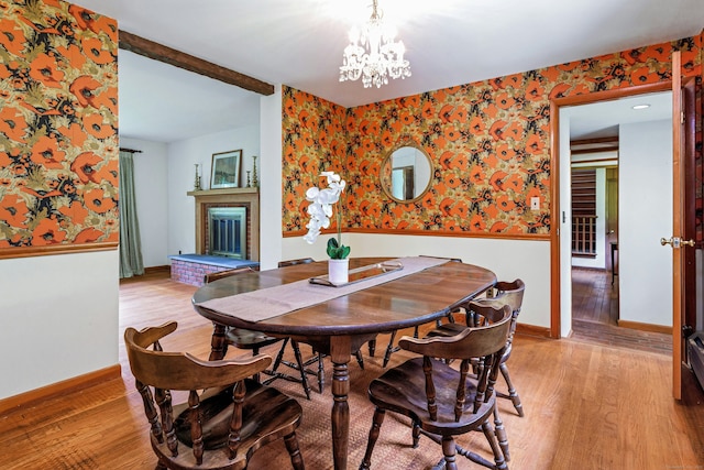 475 Hoyt St, Darien, CT 06820 - dining area featuring wallpapered walls, a fireplace, light wood-style flooring, a wainscoted wall, and baseboards