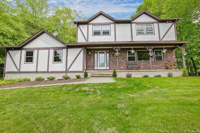 40 Spring Hill Ln, Bethel, CT 06801 - tudor house with brick siding, a front yard, stucco siding, and covered porch