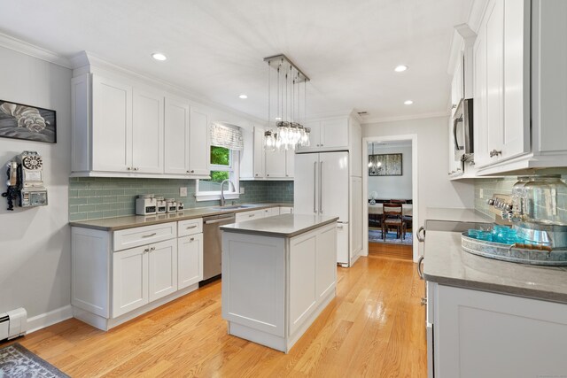40 Spring Hill Ln, Bethel, CT 06801 - kitchen with appliances with stainless steel finishes, a sink, crown molding, white cabinets, and a center island