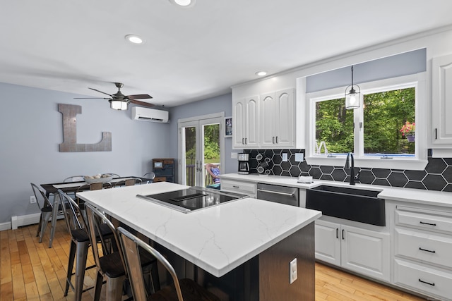114 Dean Rd, East Lyme, CT 06333 - kitchen with a sink, a wall unit AC, stovetop with downdraft, dishwasher, and a center island