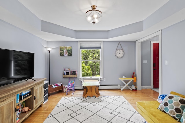 114 Dean Rd, East Lyme, CT 06333 - living room with baseboard heating, light wood-type flooring, and a raised ceiling