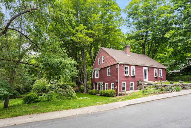 8 Cider Mill Rd, Tolland, CT 06084 - view of front of property featuring a chimney, a front yard, and view of wooded area
