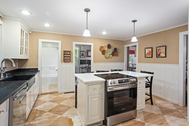 8 Cider Mill Rd, Tolland, CT 06084 - kitchen featuring stainless steel appliances, a sink, a breakfast bar, a wainscoted wall, and a kitchen island