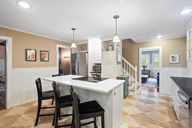 8 Cider Mill Rd, Tolland, CT 06084 - kitchen with stainless steel appliances, a wainscoted wall, light stone counters, a breakfast bar, and a kitchen island